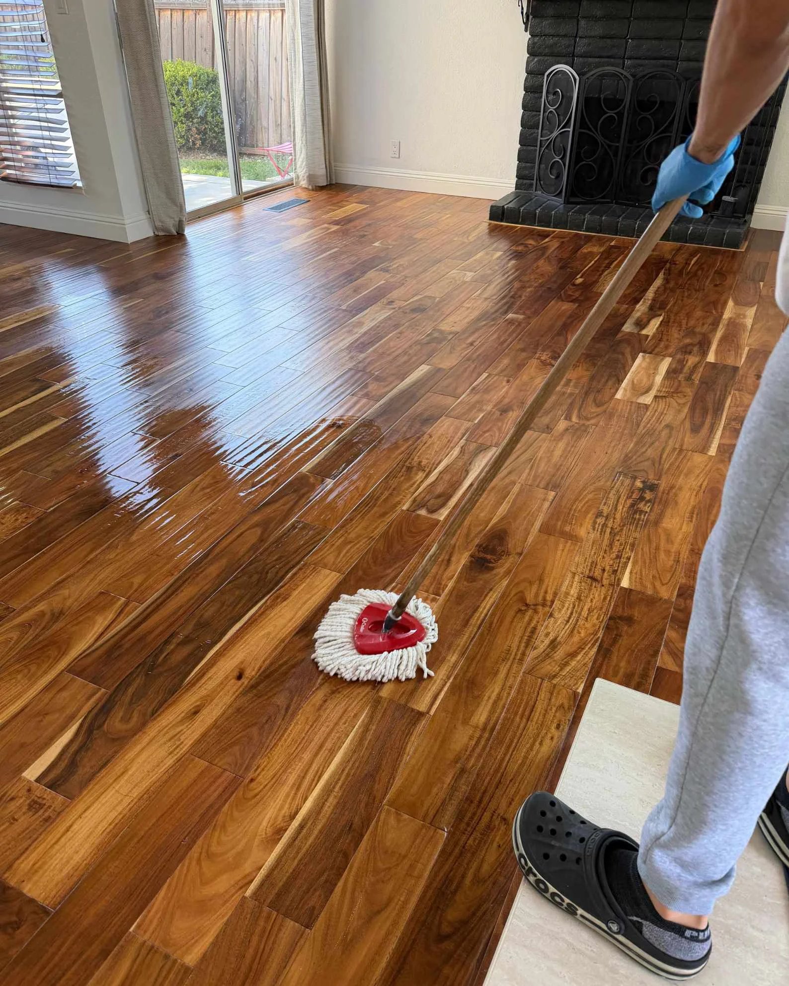 Regular house cleaning service in San Jose CA – professional mopping hardwood floor in a clean modern home